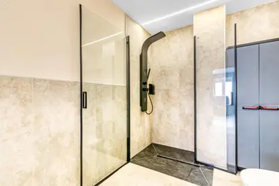 a shower with glass doors in a bathroom at City Scape Suites in Valencia