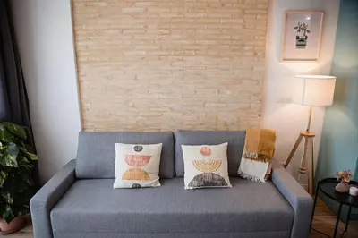 a blue couch with pillows in a living room at Lofts plaza Orense A New and close to the beach in Valencia