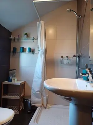 a bathroom with a sink and a shower and a toilet at Amplio duplex en la playa con piscina in Almarda