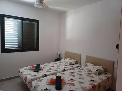 a bedroom with two beds and a window at Amplio duplex en la playa con piscina in Almarda