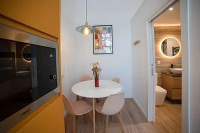 a small kitchen with a white table and a bathroom at Lofts Orense E Moderno y cercano a la playa in Valencia