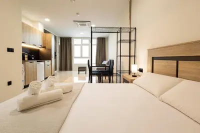 a bedroom with a large white bed and a kitchen at Vera Suites by Concept Flats in Valencia