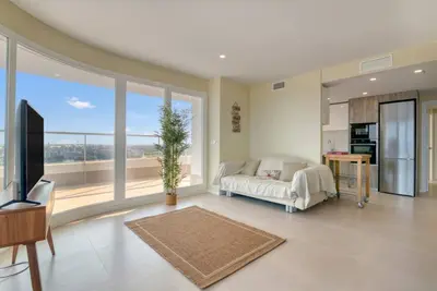a living room with a couch and a large window at Luxury Penthouse with Panoramic Sea Views in Canet de Berenguer