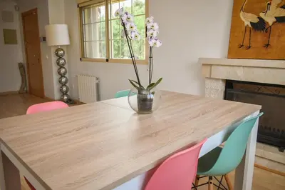 a wooden table with a vase with flowers on it at Sunny House La Eliana in La Eliana