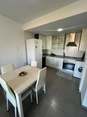 a kitchen with a table and chairs and a white refrigerator at Apartamento en Moncofa in Moncófar