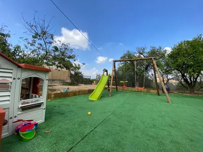 a playground with a slide and a swing at Guesthouse in Torrent in Valencia