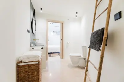 a white bathroom with a toilet and a sink at Loft Viñas in Valencia