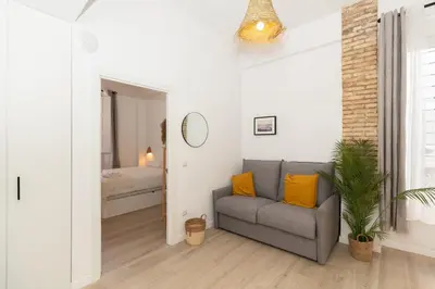 a living room with a couch and a bedroom at Illetes Flats -Apartamento con mucho encanto in Valencia