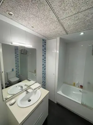 a bathroom with a sink and a tub and a mirror at Apartamento playa Veramar patacona in Valencia