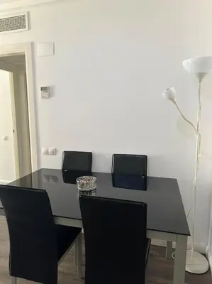 a dining room table with four chairs and a lamp at Apartamento playa Veramar patacona in Valencia