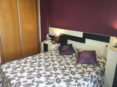 a bedroom with a large bed with purple pillows at Apartamento en la Playa de Canet de Berenguer in Canet de Berenguer