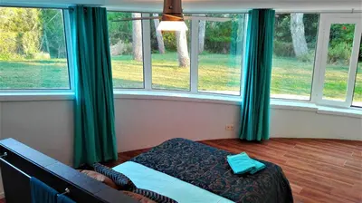a bedroom with green curtains and a bed in front of a window at All Nature Villa-25min from Valencia in Valencia