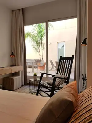 a bedroom with a bed and a chair and a patio at Hotel Boutique Balandret in Valencia