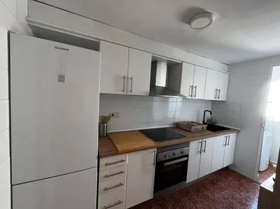 a kitchen with white cabinets and a white refrigerator at Tu Refugio con Vistas al Mar in Puebla de Farnals
