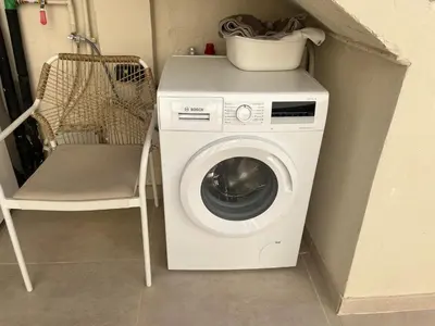 a washing machine and a chair in a room at Ca Erika in Aldaia