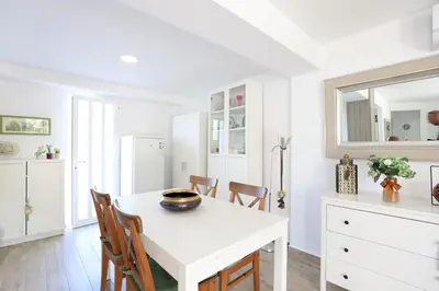 a white dining room with a white table and chairs at 2 apartamentos en una excelente villa de playa compartiendo Piscina y Jardín in Sagunto