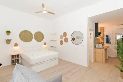 a white bedroom with a bed and a ceiling fan at Illetes Flats - Loft encantador cerca de Bioparc in Valencia