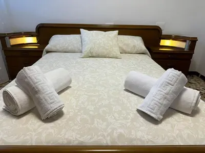 a bed with three pillows and towels on it at Casa Rural Piker in Bolbaite