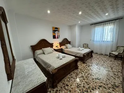 a room with two beds and a chair in it at Casa Rural Piker in Bolbaite