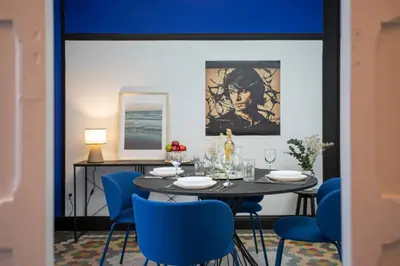 a dining room with a table and blue chairs at SingularStays Ca Iconic Living in Valencia