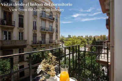 a table with a glass of orange juice on a balcony at SingularStays Ca Iconic Living in Valencia