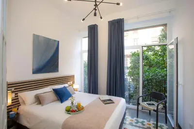a bedroom with a bed and a table and a window at SingularStays Ca Iconic Living in Valencia