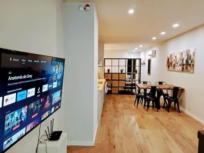 a dining room with a table and a large screen at Artes y ciencias D with fast Wifi and terrace in Valencia