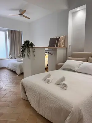 a white bedroom with a large bed and a couch at Apartamento mediterráneo in Valencia