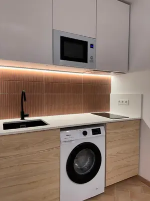 a kitchen with a washing machine and a microwave at Apartamento mediterráneo in Valencia