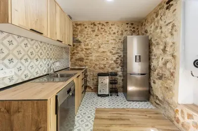 a kitchen with wooden cabinets and a stainless steel refrigerator at Casa rural las golondrinas in Quesa