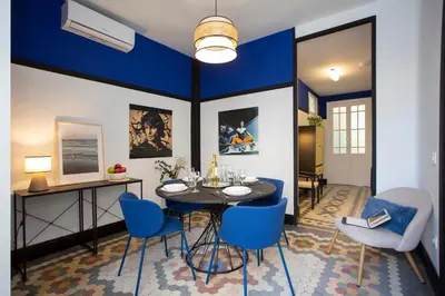 a dining room with a table and blue chairs at SingularStays Ca Iconic in Valencia