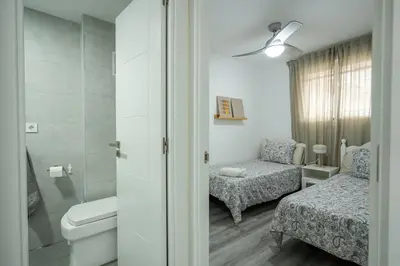 a bathroom with a bed and a chair and a toilet at 1ª Linea de Mar 4pax Valencia 15 min in El Perellonet