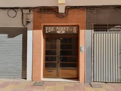 a door to a building with a sign above it at Cosy apartment near the beach in Cullera