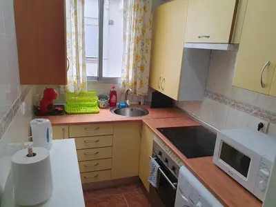 a small kitchen with a sink and a microwave at Cosy apartment near the beach in Cullera
