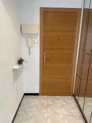 a hallway with a wooden door in a room at Tranquila y Céntrica Habitación Individual en Vivienda Compartida in Valencia