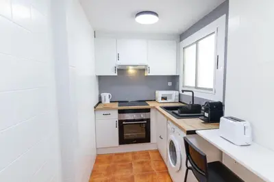 a kitchen with white cabinets and a washer and dryer at GuestReady - El Cabanyal stay near the beach in Valencia