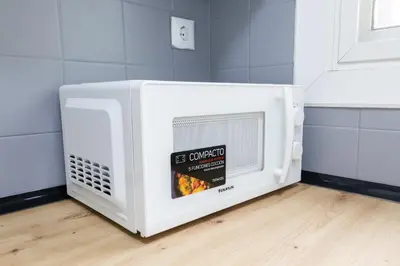 a microwave oven sitting on the floor in a kitchen at GuestReady - El Cabanyal stay near the beach in Valencia