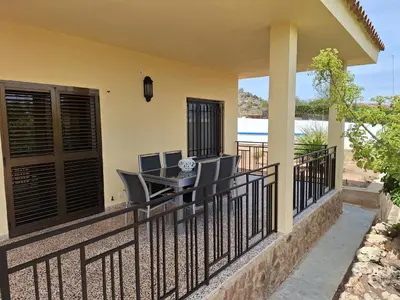 a balcony with a table and chairs on it at Villa cerca de Valencia con piscina junto a la montaña in Vilamarxant