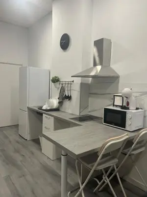 a kitchen with a microwave and a table with chairs at Maravilloso Loft - B in Valencia