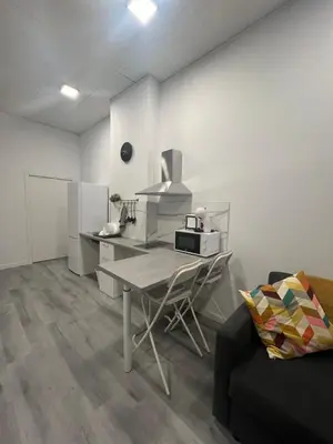a white kitchen with a table and a microwave at Maravilloso Loft - B in Valencia