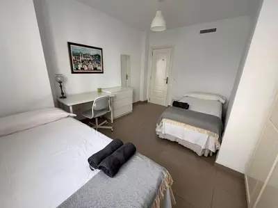 a hotel room with two beds and a desk and a desk at Amplio y cómodo apartamento en el centro in Valencia