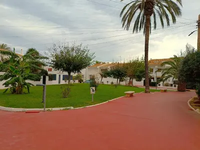 a park with a palm tree and a red sidewalk at Play-Puig Beach Flat in El Puig