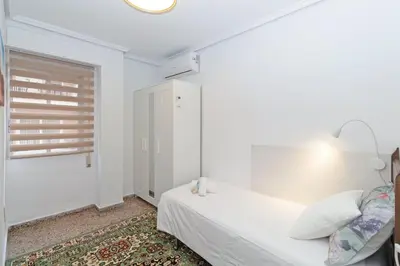 a white bedroom with a bed and a window at GuestReady - Lindo piso muy espacioso en Valencia in Valencia