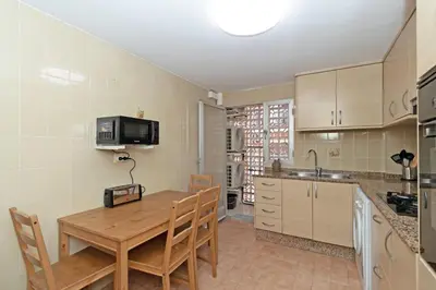 a kitchen with a wooden table with chairs and a sink at GuestReady - Lindo piso muy espacioso en Valencia in Valencia
