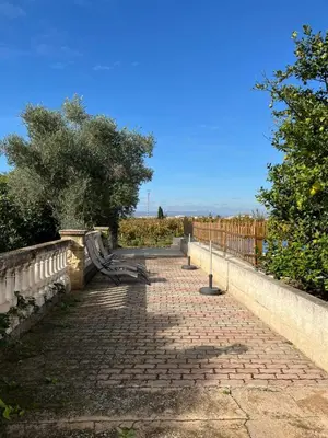 a brick path with a bench on the side of a fence at Casa Rural Huerto del Carmen in Puebla Larga
