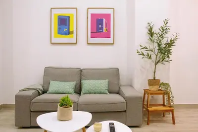 a living room with a couch and paintings on the wall at La Brisa Lofts in Valencia