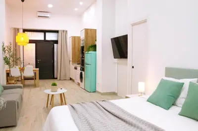 a bedroom with a bed and a couch and a kitchen at La Brisa Lofts in Valencia