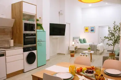 a kitchen and living room with a table and a room with at La Brisa Lofts in Valencia