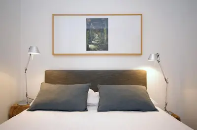 a bed with two lamps and a picture on the wall at Vivaldi Penthouse Ayuntamiento in Valencia