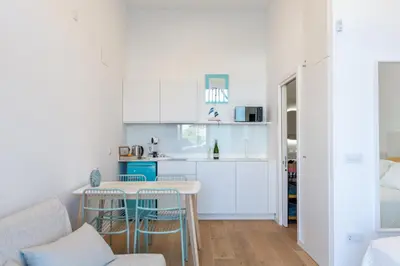 a kitchen with white cabinets and a table and chairs at Estudio Marina Ivana in Valencia